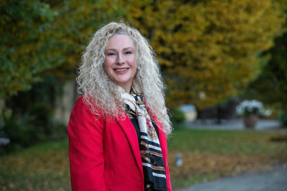 Fair haired woman in red coat.
